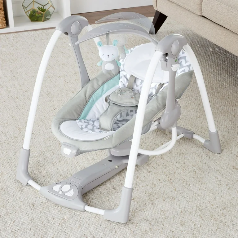 Ingenuity baby swing with infant sleeping peacefully in portable swing with soothing motion and calming sounds for parents seeking reliable baby gear